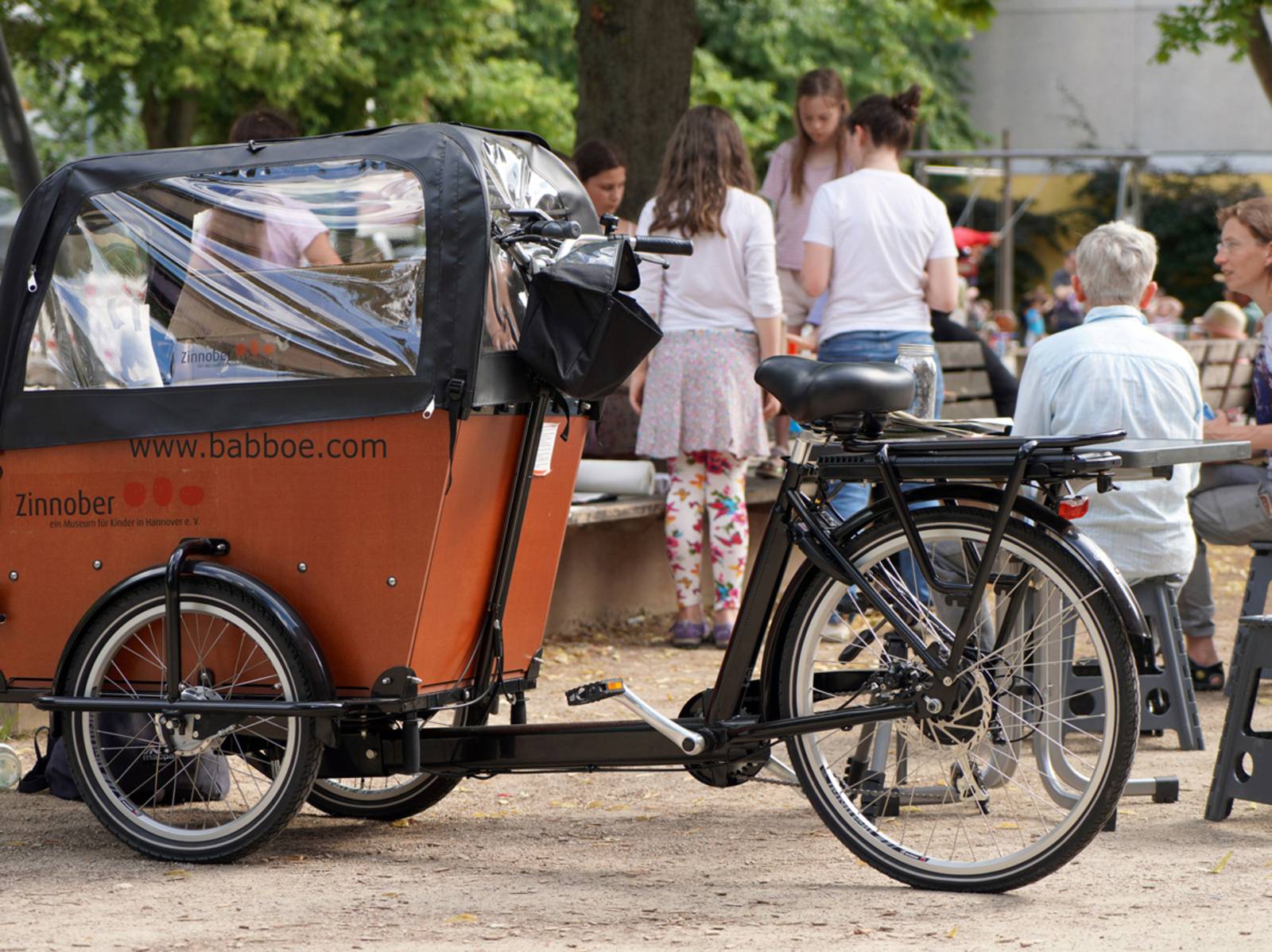 Ein Lastenrad. Drumherum Menschen.